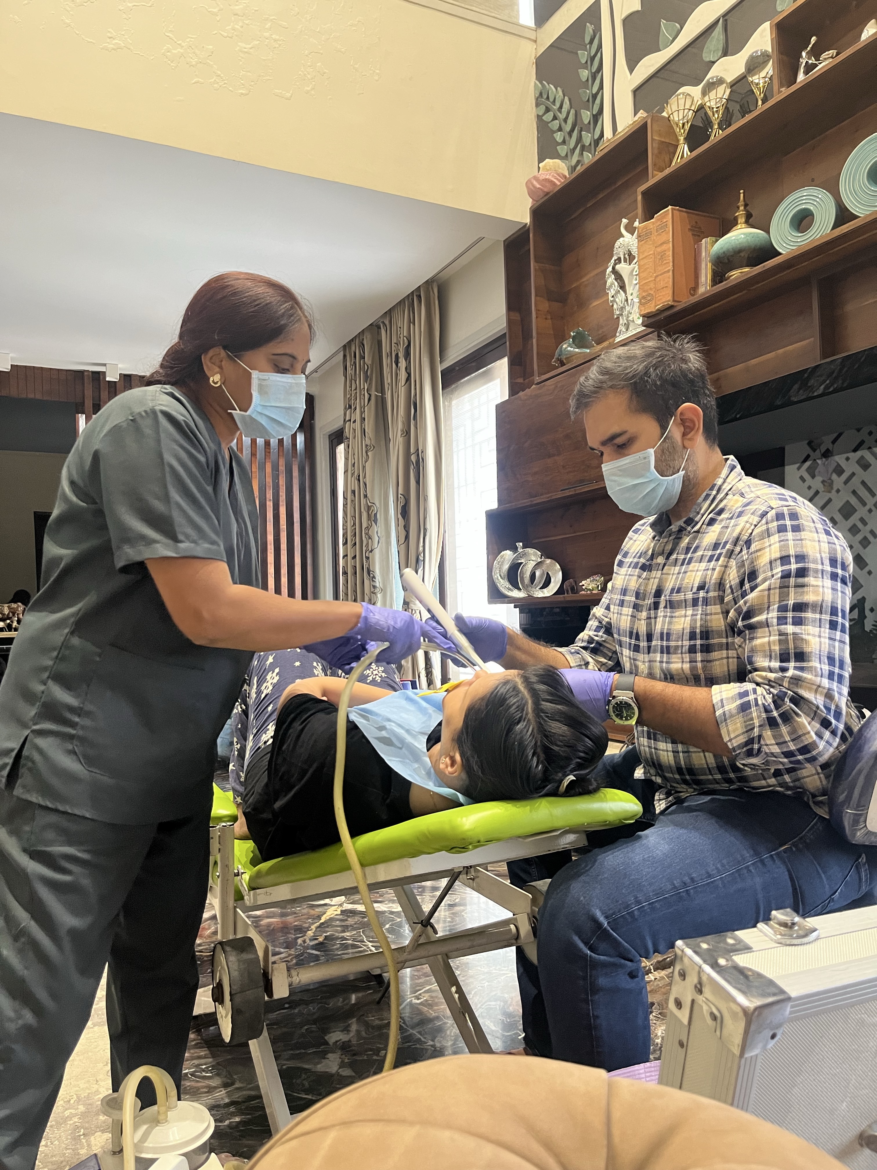 Prudentoe dentists providing professional dental care in a patient's living room in Hyderabad